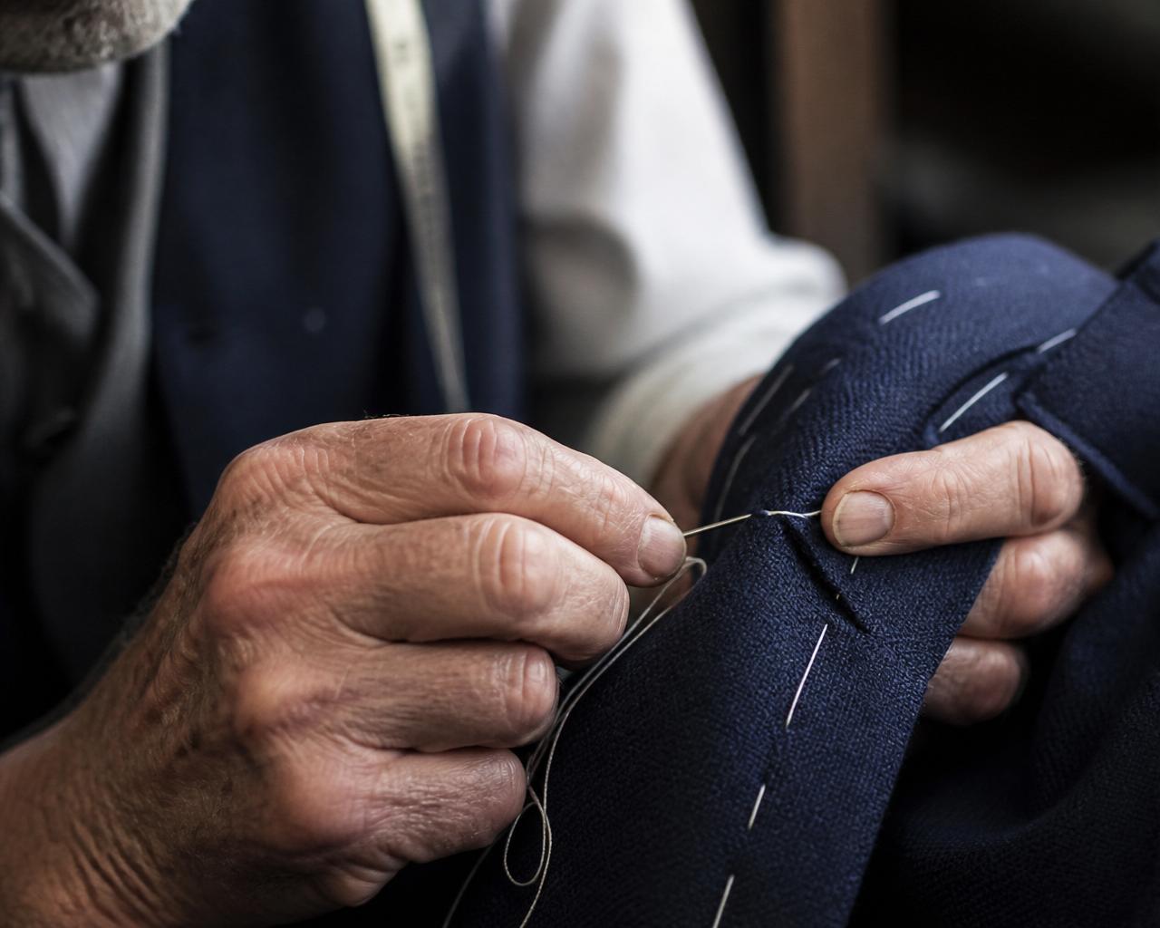 Master tailor hand-stitching a bespoke navy suit lapel in San Diego